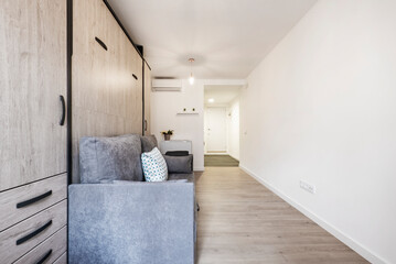 Obraz premium Rollaway bed inside sofa with cushions in short-term rental studio