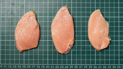 Chicken thigh meat on a linear board. Raw chicken thigh with skin, boneless, for cooking.