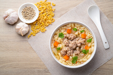 Macaroni Soup with minced pork ,carrots and onion ,easy asian style clear soup in white bowl.Top...