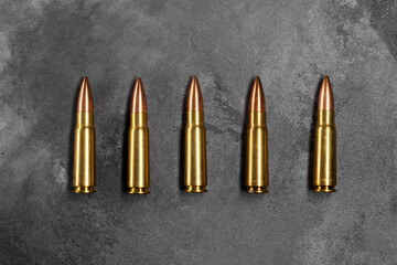Bullets on gray background. Cartridges 7.62 caliber for Kalashnikov assault rifle. Top view, flat...