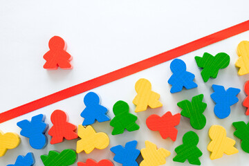 red line between wooden figurines of people, concept of discrimination, social inequality