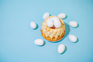 Easter cake with eggs on blue background. Polish babka - traditional Easter funnel cake