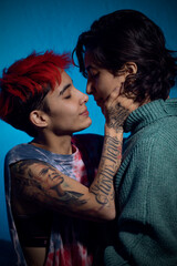 close up of a lesbian couple about to kiss against a blue background