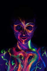 close-up of a girl's face made up with coloured fluorescent paint on her face