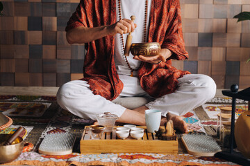 Tibetan singing bowl in the hands of a man during a tea ceremony