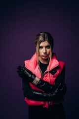 Modern design. Young beautiful female fashion model in clothes on a purple background. Concept of design, fashion, vintage style, sportstyle