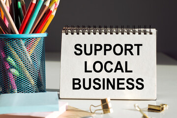 support local business handwritten on notebook on office background