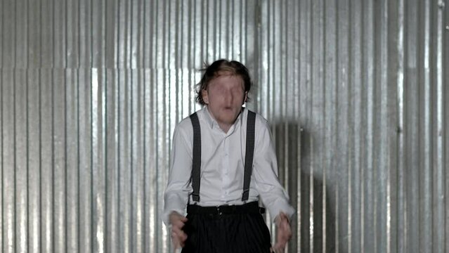  Crazy Artist man show emotional entertainment at background of metallic wall. Epileptic tremor man.