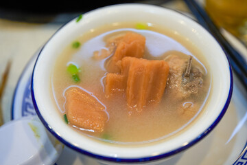 A bowl of delicious and sweet lotus root pork ribs soup close-up