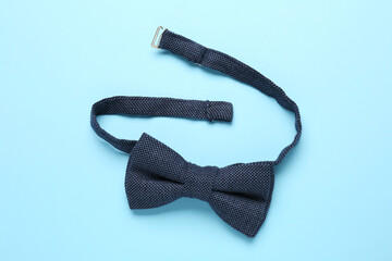 Stylish bow tie on light blue background, top view