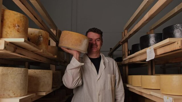 The cheese maker stands between the shelves 