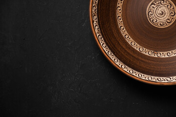 Ancient clay plate on a black background