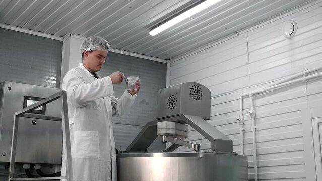 A cheese maker checks a cheese blank for curdling