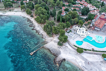 Sea shore with empty pier and hotel building with the pool