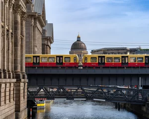 Fototapeten Berlin, Germany: S-Bahn train passing by on the bridge of Museum Island. The building of Humboldt Forum on the background © LoCrew