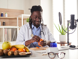 young nutritionist take a break in office and eat a tangerine