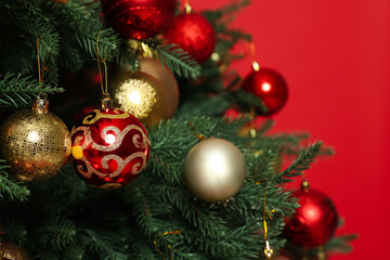 Obraz na płótnie Canvas Beautifully decorated Christmas tree against red background, closeup