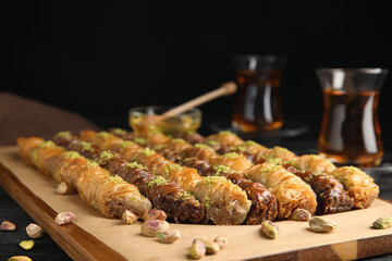 Delicious sweet baklava with pistachios on wooden board, closeup