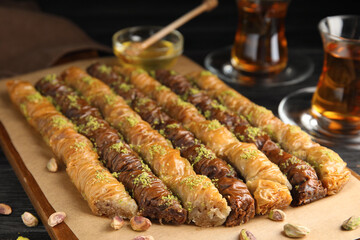 Delicious sweet baklava with pistachios on wooden board, closeup