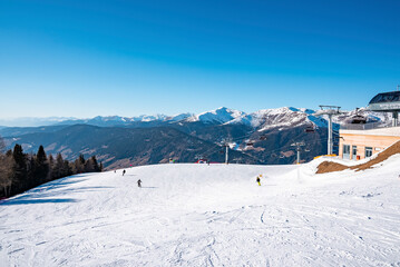 View of tracks by ski station and snow covered majestic mountains against sky