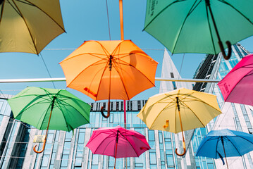Bunte Regenschirme der Demokratie als Dekoration vor blauen Himmel in Leipzig Deutschland