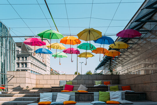 Bunte Regenschirme im Zeichen der Demokratie als Dekoration vor blauen Himmel in Leipzig Deutschland
