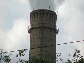 large factory chimney that emits smoke. The concept of environmental pollution. selective focus
