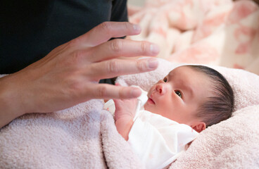 Fototapeta na wymiar 手を見つめる赤ちゃん