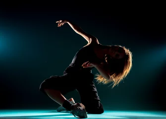 Fototapeten Modern dance performer practicing modern dance on dark wall © qunica.com