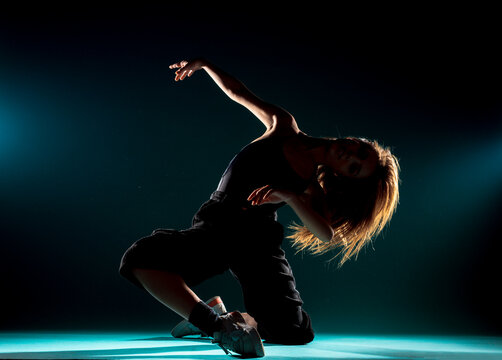 Modern dance performer practicing modern dance on dark wall