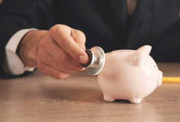 Piggy bank with stethoscope, tax offset concept