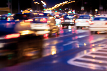blurred view of cars in motion with bright headlights. city road at night.