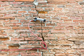 Electric digital crack measuring device reading, by cable, the minimal deformation and movement of...