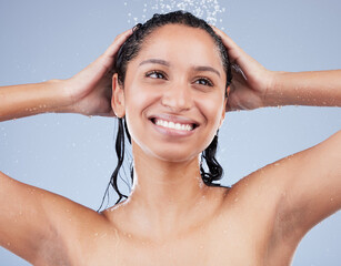 A good shower can boost your mood. Shot of a young woman washing her hair in the shower against a...