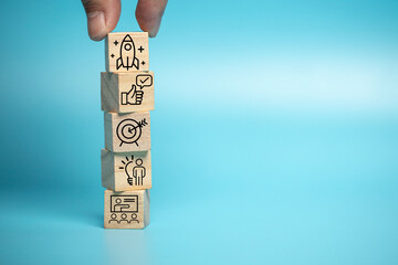 Businessman puts a wooden block of business symbols. Marketing and product planning ideas, startups, product manufacturing orientations. - obrazy, fototapety, plakaty