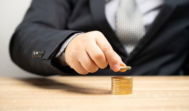 Businessman laying gold coins in layers future financial investment money planning theory