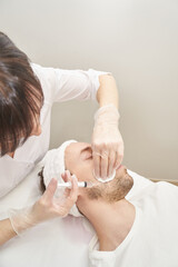 Injection at spa salon. Doctor hands in gloves. Closeup. Pretty male patient. Beauty treatment....