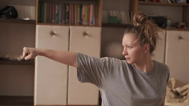 Woman practicing qigong at her cozy apartment
