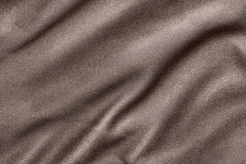 Gray fabric with wrinkles. Knitted fabric background with folds. The texture of the fabric. Dark background. Top view.