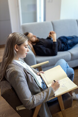 Young man talking to female psychologist during session.