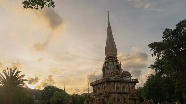 time lapse sunset at Chalong pagoda Phuket Thailand..colorful cloud above pagoda of Chalong pagoda in twilight..beautiful architecture pagoda of Chalong temple in the night..