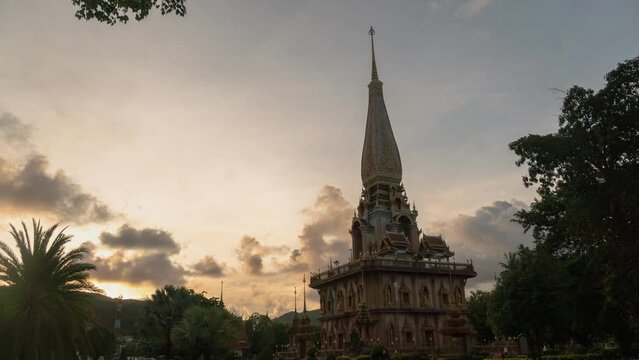 time lapse sunset at Chalong pagoda Phuket Thailand..colorful cloud above pagoda of Chalong pagoda in twilight..beautiful architecture pagoda of Chalong temple in the night..