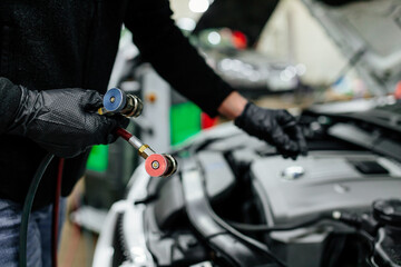 Professional car mechanic servicing car air conditioner. Car repair shop.