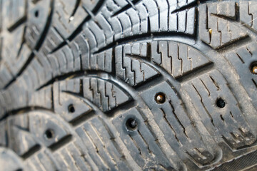 Fallen and worn spikes on the car tire. Close-up