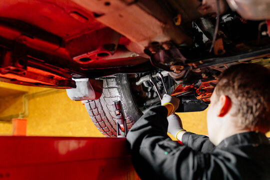 Car mechanic installing wheel alignment sensors, car suspension adjustment. Car mechanic at work