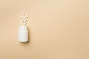 White bottle with pills on color background