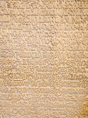 Ancient Greek writing in stone. A wall with ancient Greek letters. Historical archaeological background
