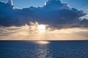 Obraz premium Sun breaks through clouds and leaves spotlight on water