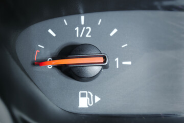 Naklejka premium Close up of a fuel gauge showing an empty fuel tank in a car. Transportation with fossil fuel, high fuel and oil price.