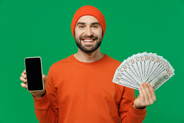 Young smiling happy man 20s in orange sweatshirt hat hold mobile cell phone with blank screen...